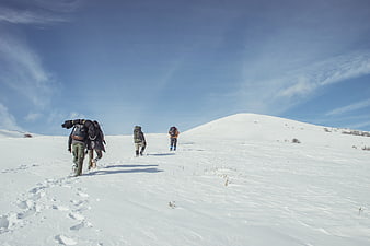 Group of hikers trekking up a snowy mountain slope
