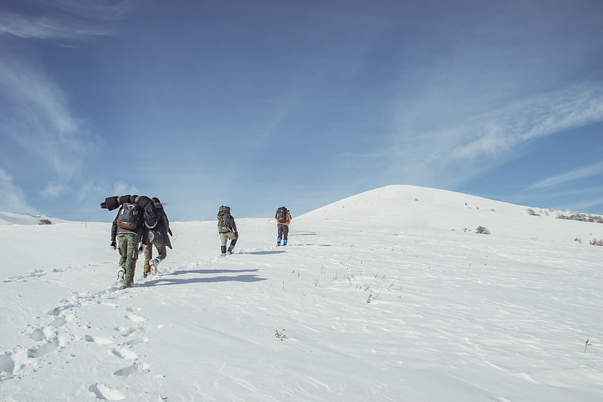 Group of hikers trekking up a snowy mountain slope