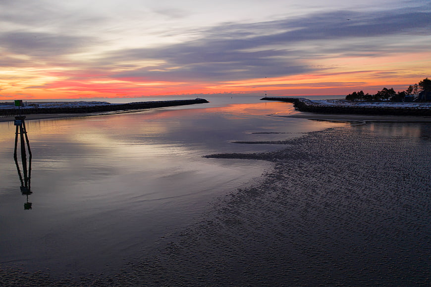 Serene Sunset Over Calm Harbor Entrance With Reflections
