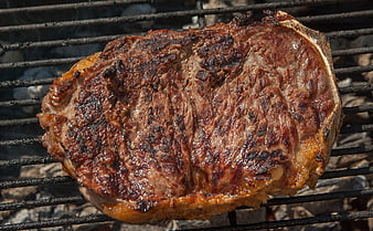 Sizzling Ribeye Steak Grilling on Outdoor Barbecue