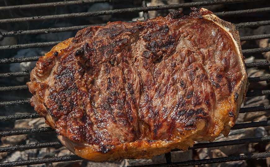 Sizzling Ribeye Steak Grilling on Outdoor Barbecue