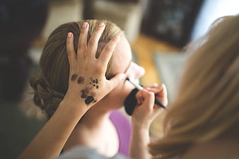 Makeup artist applying eyeshadow with swatches on hand