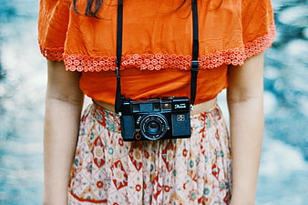 Woman with Vintage Camera and Orange Top