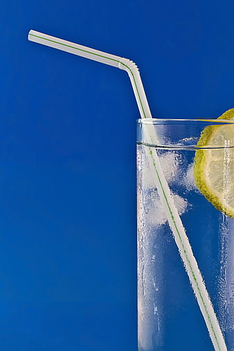 Refreshing Cold Drink with Lemon Slice and Straw on Blue Background