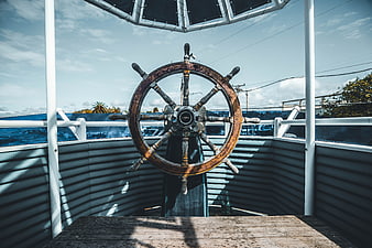 Rusty wooden ship steering wheel on a boat deck