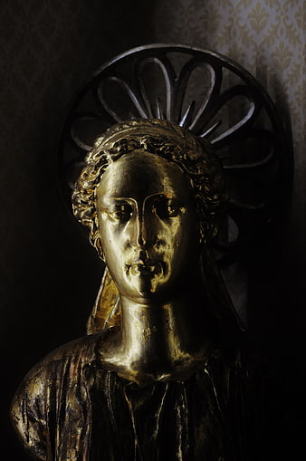 Golden angel statue with halo in dramatic lighting