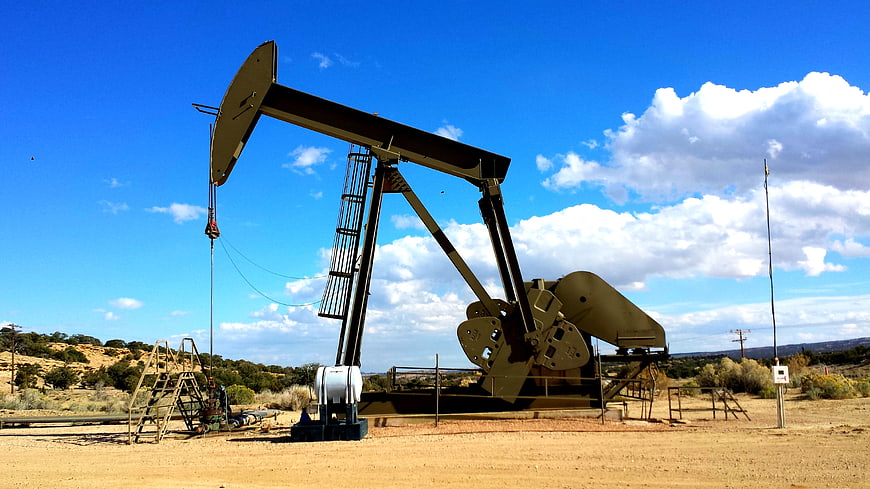 Oil Pump Jack in Desert Landscape Under Blue Sky
