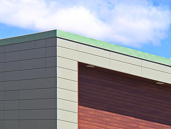 Modern building facade with green roof and wood paneling