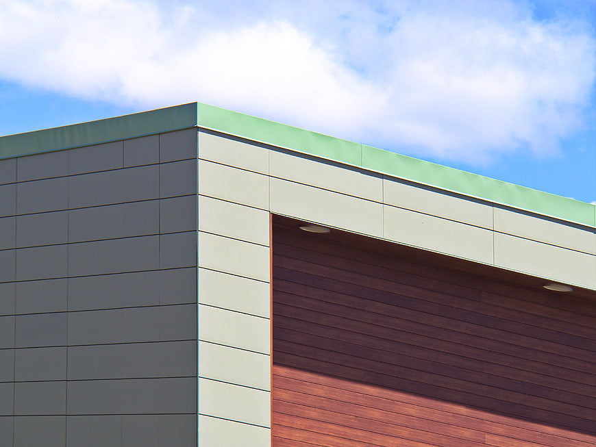 Modern building facade with green roof and wood paneling