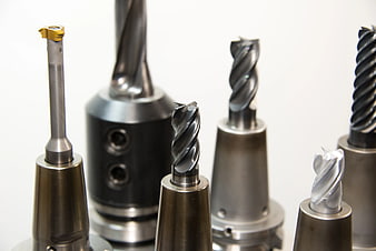 Assortment of CNC milling cutters and drill bits on white background