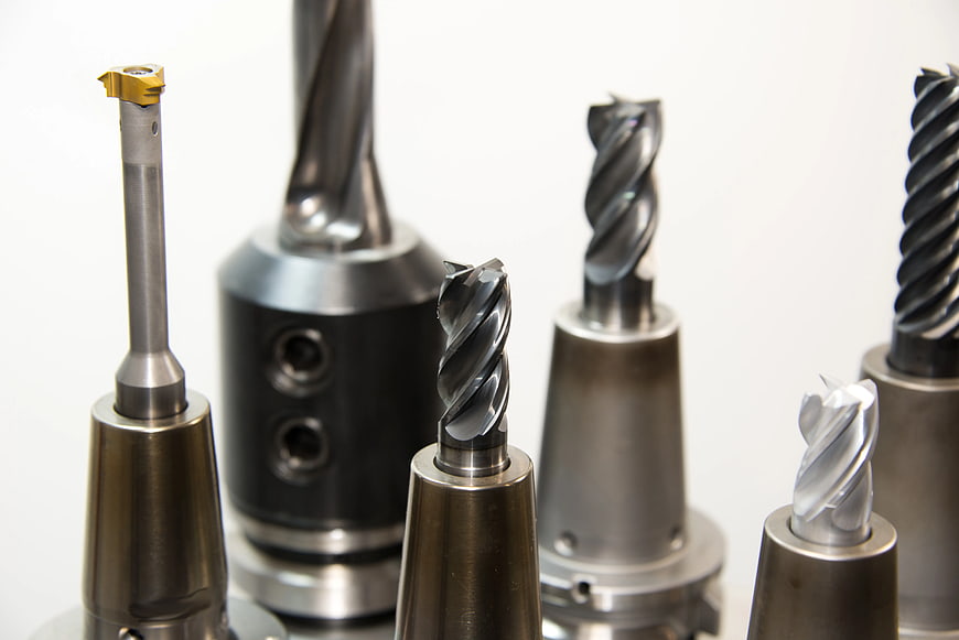Assortment of CNC milling cutters and drill bits on white background