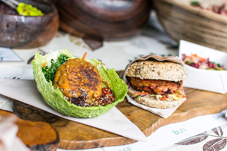 Vegan burger and lettuce wrap on wooden board