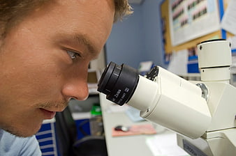 Close-up of Scientist Looking Through Microscope in Laboratory