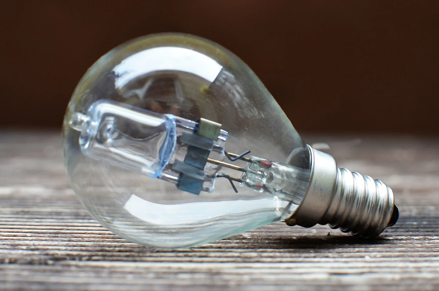 Clear LED light bulb on rustic wooden surface