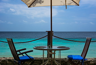 Empty Beach Terrace with Ocean View and Blue Chairs