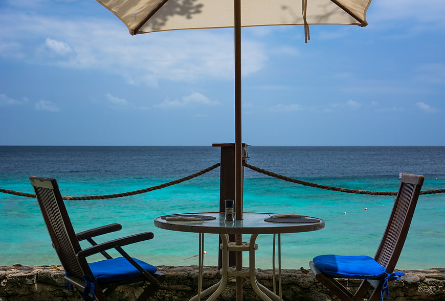 Empty Beach Terrace with Ocean View and Blue Chairs