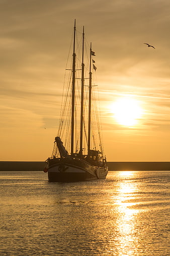 Silhouette of Three-Masted Sailboat at Golden Sunset