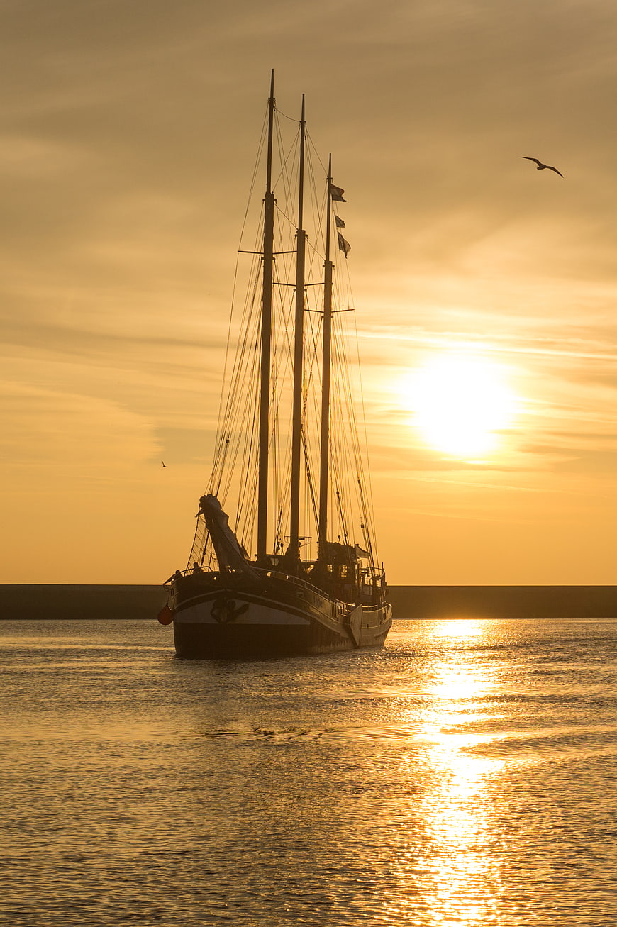 Silhouette of Three-Masted Sailboat at Golden Sunset