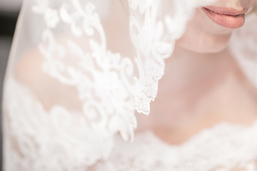 Close-up of bride's lips and lace veil detail