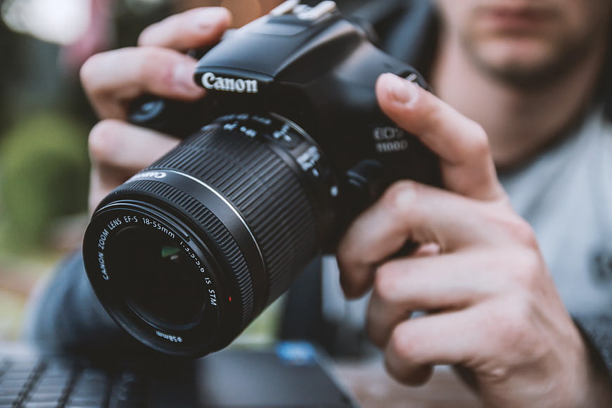 Close-up of Hands Holding Canon DSLR Camera Lens