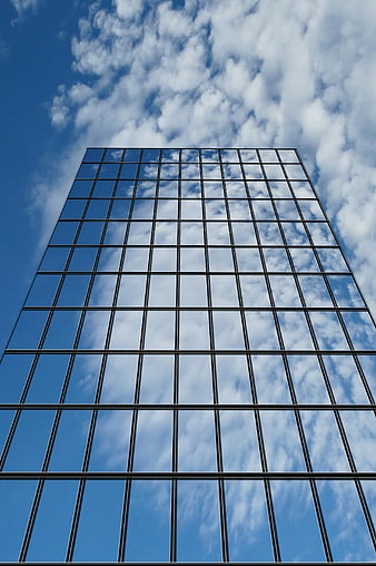 Low Angle View of Modern Glass Skyscraper Reflecting Clouds