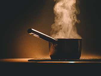 Steaming Saucepan on Stove in Warm Kitchen Lighting