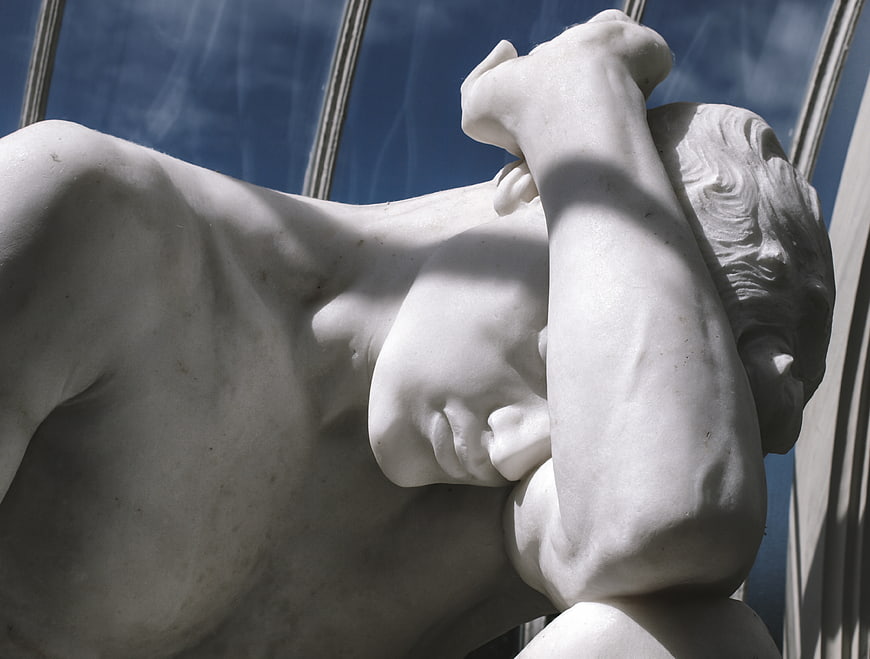 Close-up of classical marble statue torso and arm