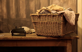 Vintage Wicker Laundry Basket And Old Iron On Wooden Table
