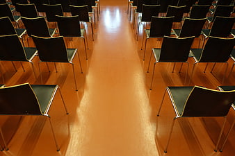 Empty rows of black chairs in a lecture hall