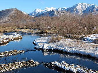 Snowy River Winding Through Winter Valley with Mountains