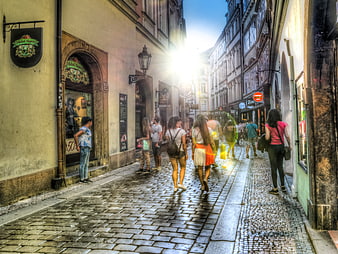 Tourists walking down cobblestone street in Prague