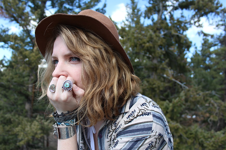 Young woman in hat looking away in forest