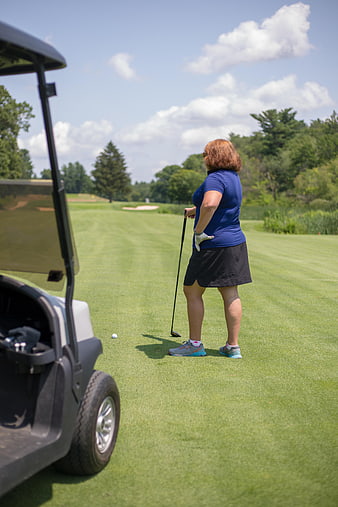 Woman Golfer Preparing to Swing on Green Course