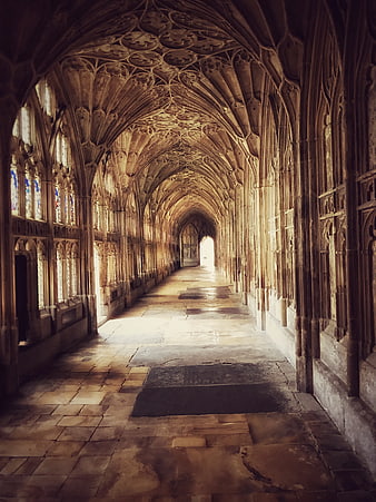 Gothic Vaulted Hallway with Stone Arches and Stained Glass