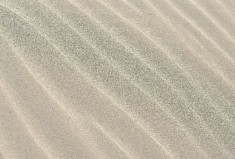 Close-up texture of rippled sand dunes with natural patterns
