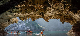 Kayakers Exploring Bat Cave In Halong Bay Vietnam