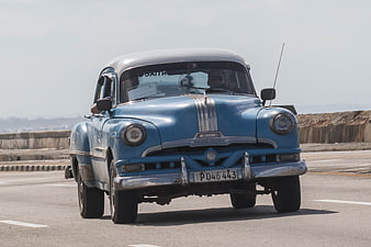 Vintage Blue Classic Car Driving on Havana Malecon Road