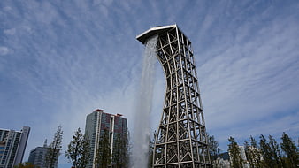 Tall Steel Water Tower Structure With Waterfall In Urban Park