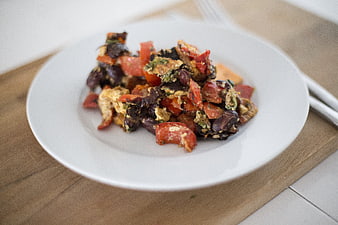 Healthy vegetable scramble with tomatoes and beans on white plate
