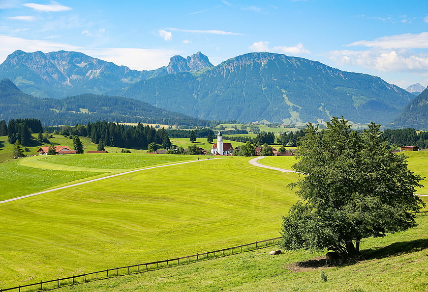 Scenic Alpine Landscape with Church and Green Pastures