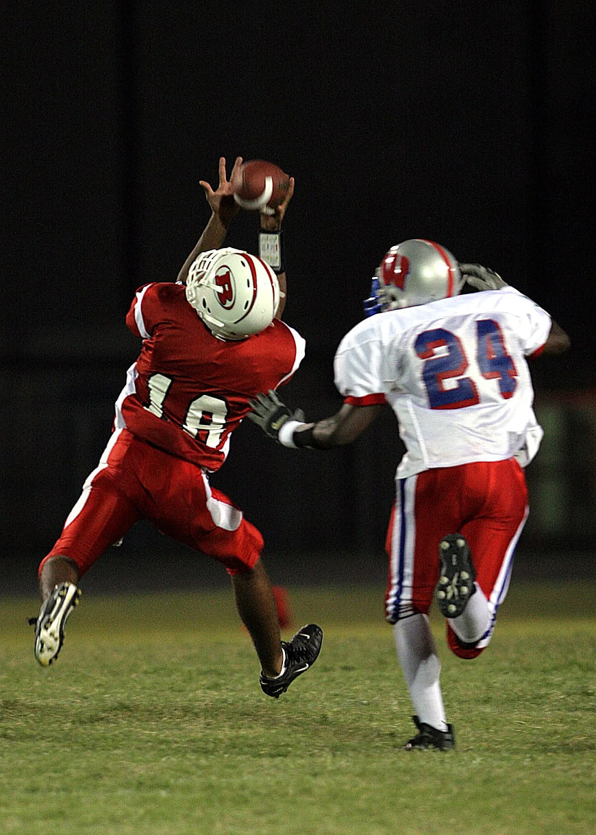 American Football Player Catching Ball at Night