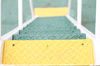 Green and yellow metal stairs with diamond plate texture