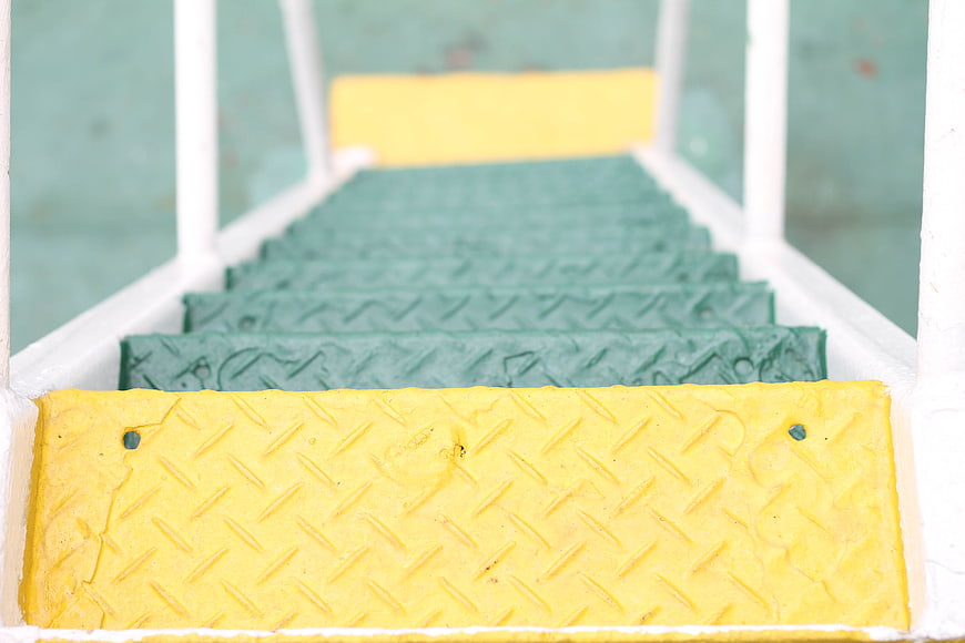Green and yellow metal stairs with diamond plate texture