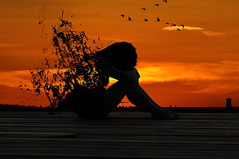 Silhouette of Sad Woman Sitting at Sunset with Birds