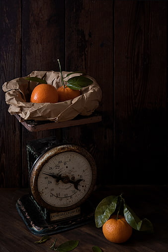 Vintage kitchen scale with fresh oranges on dark wood