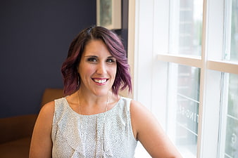 Smiling woman with purple hair in office portrait