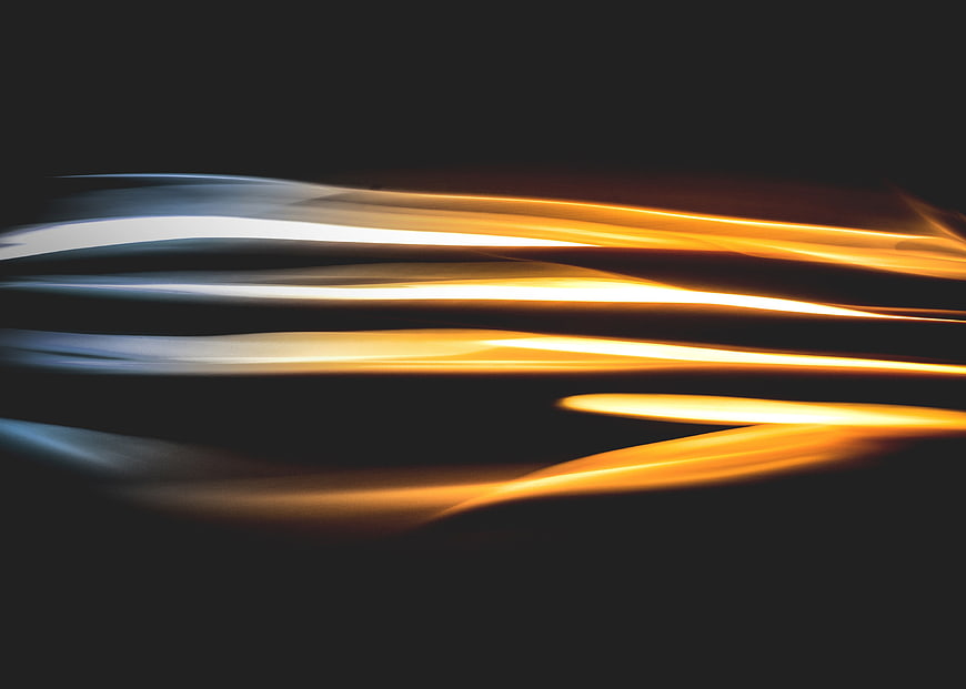 Abstract Light Trails in Orange and Blue on Dark Background