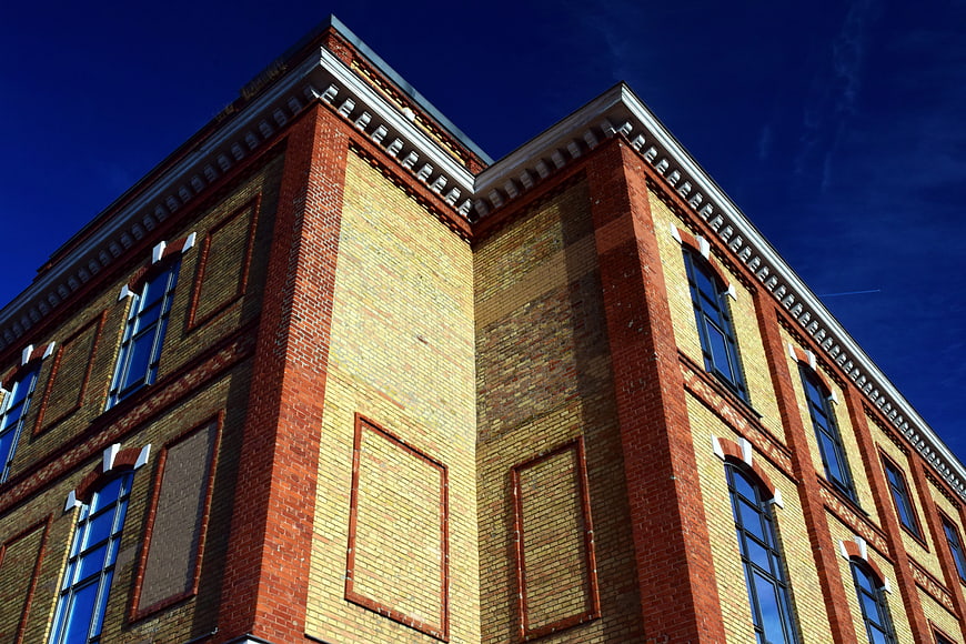 Low angle view of historic red brick factory building facade