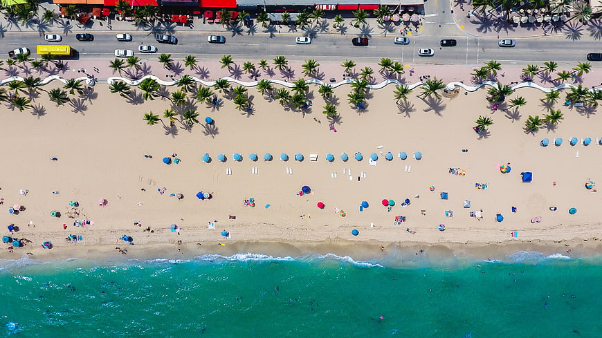 Aerial View of Busy Tropical Beach with Turquoise Ocean