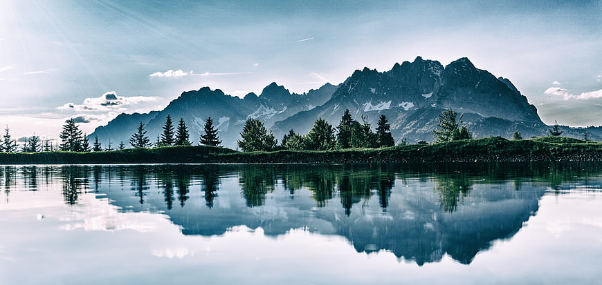 Serene Alpine Lake with Mountain Reflection and Pine Trees